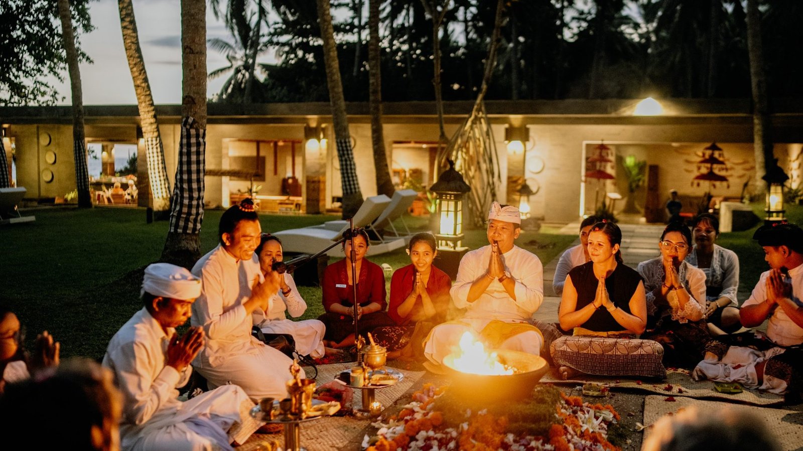 A fire ceremony at dusk in a villa garden